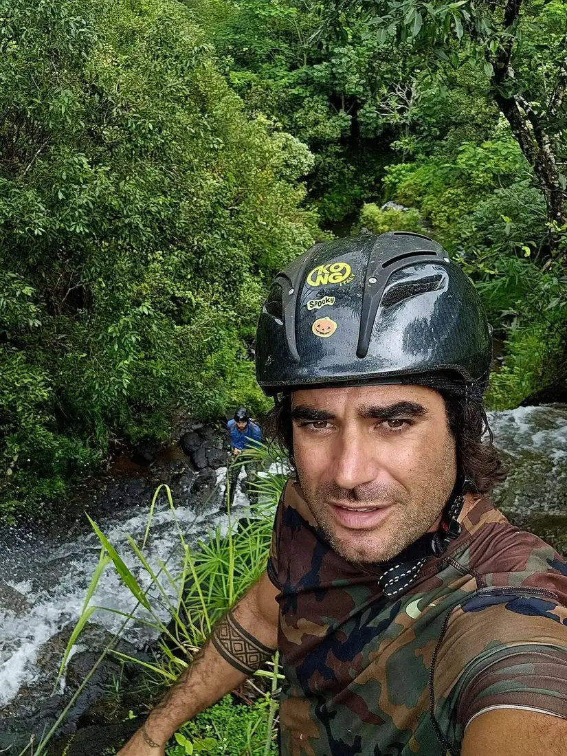 Renan in a helmet in a jungle canyon
