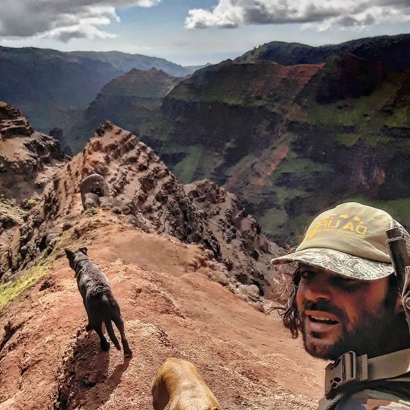 Renan Gobbet Hernandez on a ridge above a canyon with his dog