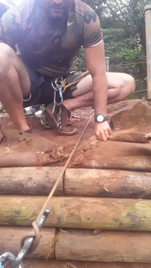 Rigging a heavy log into place with rope