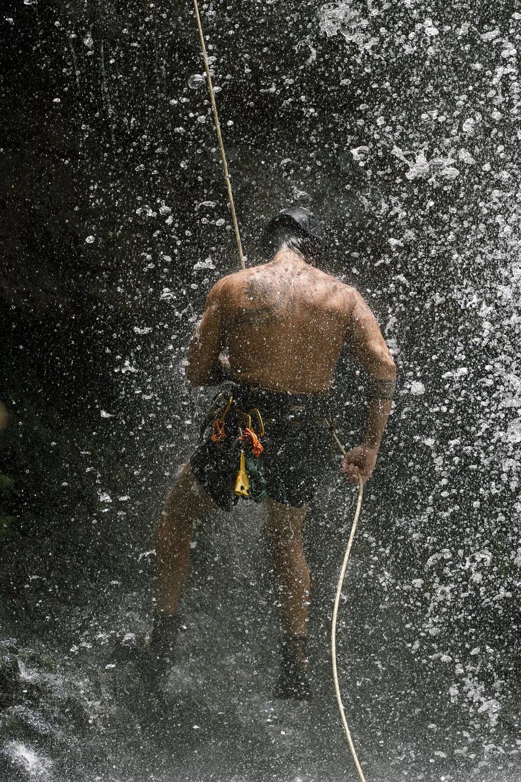 Rappelling through the spray of a waterfall