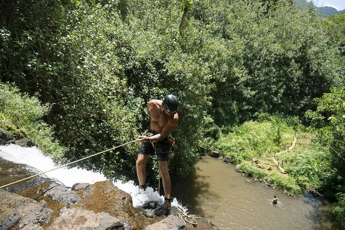 Rigging a rappel line at the top of a waterfall