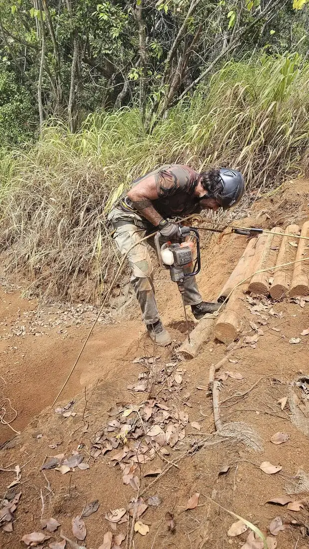Renan cutting crib steps into a steep trail